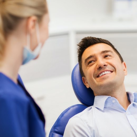 Man smiling at dentist after tooth extractions